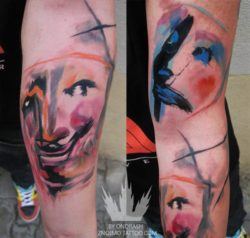 Happy and sad drama masks get a makeover in this colorful watercolor tattoo by Ondrash