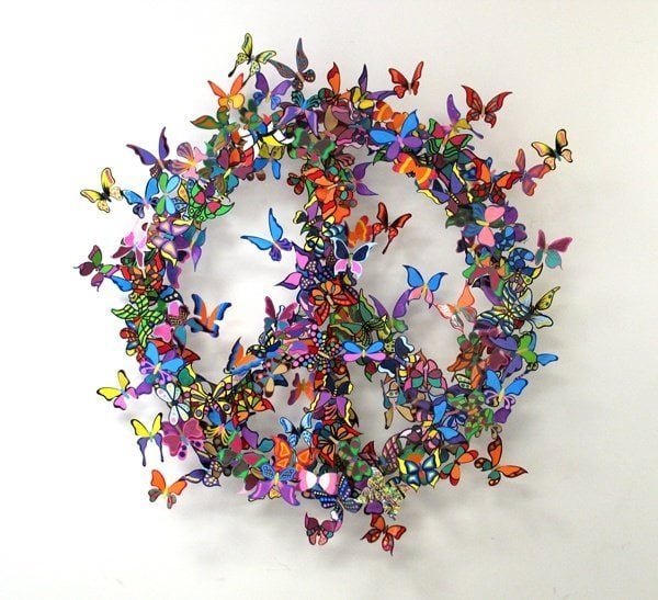A David Kracov metal sculpture art work that uses colorfully painted butterflies to create a peace sign