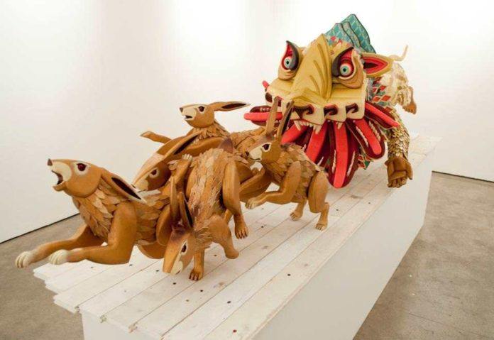 An interesting wooden art construction by AJ Fosik of a mythological beast chasing rabbits