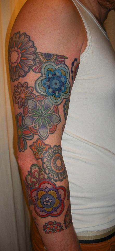 Mandala flowers decorate this guys arm in this henna inspired tattoo deign by Barbara Swingaling
