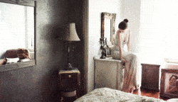 A beautiful model kicks her foot as she sits on an antique dresser in this animated GIF by Cinemagraphs