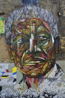 French graffiti artist Hopare paints a street art mural of Nelson Mandela in an artistic graphic style